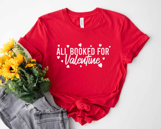A red color shirt with the saying "All booked for valentine"