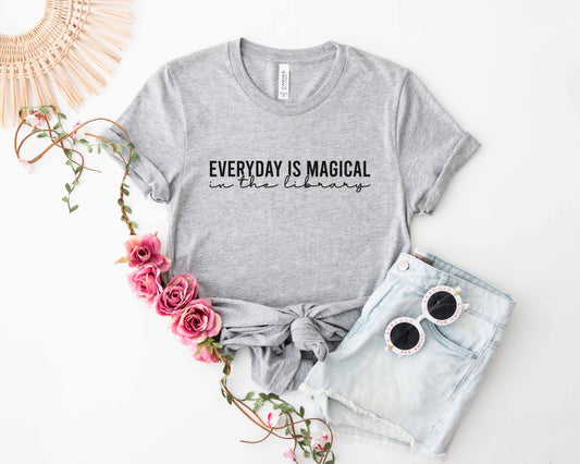 An athletic heather color shirt with the saying "Everyday is magical in the library"