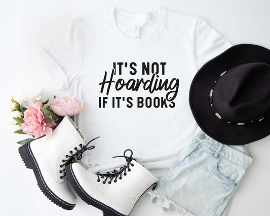 A white color shirt with the saying "It's not hoarding if it's books"