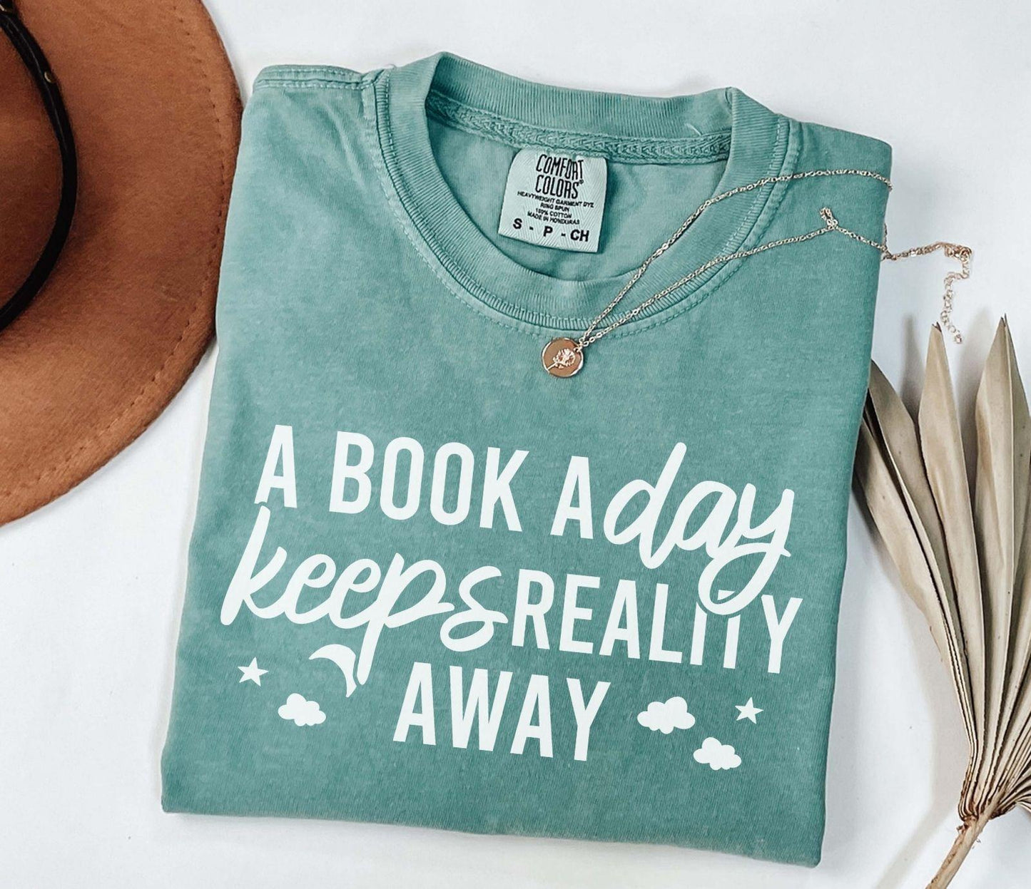 A comfort colors® shirt with the saying "A book a day keeps reality away"