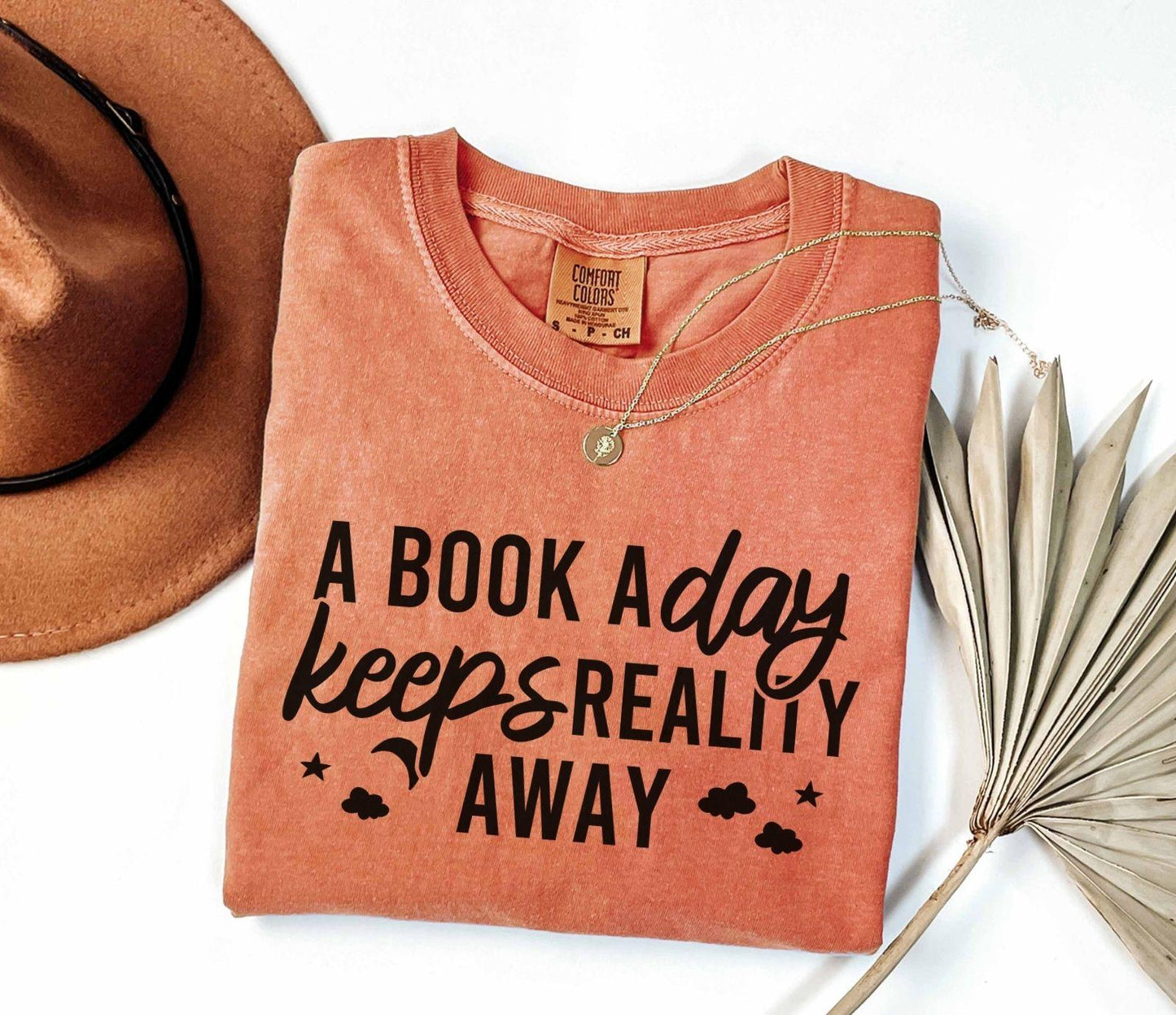 A comfort colors® shirt with the saying "A book a day keeps reality away"