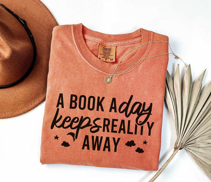 A comfort colors® shirt with the saying "A book a day keeps reality away"