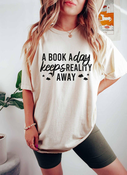 A comfort colors® shirt with the saying "A book a day keeps reality away"