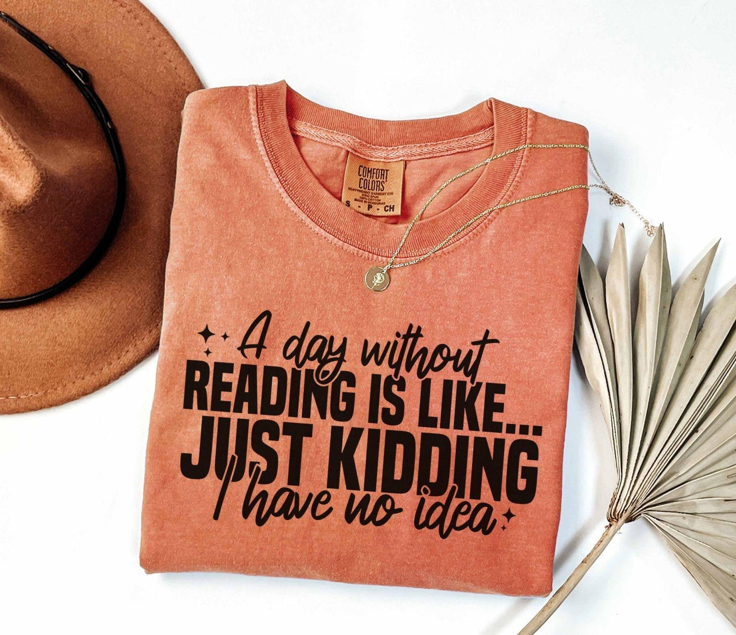 A comfort colors shirt with the saying "A day without reading is like just kidding I have no idea""
