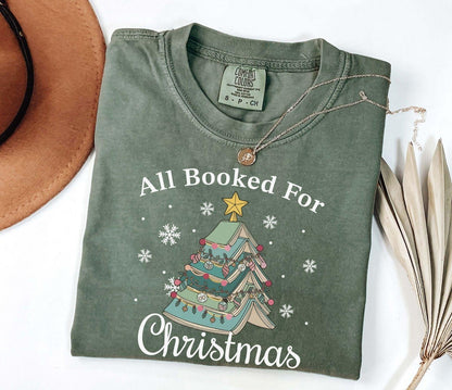A comfort colors® shirt with the saying "All booked for Christmas"