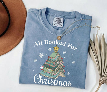 A comfort colors® shirt with the saying "All booked for Christmas"