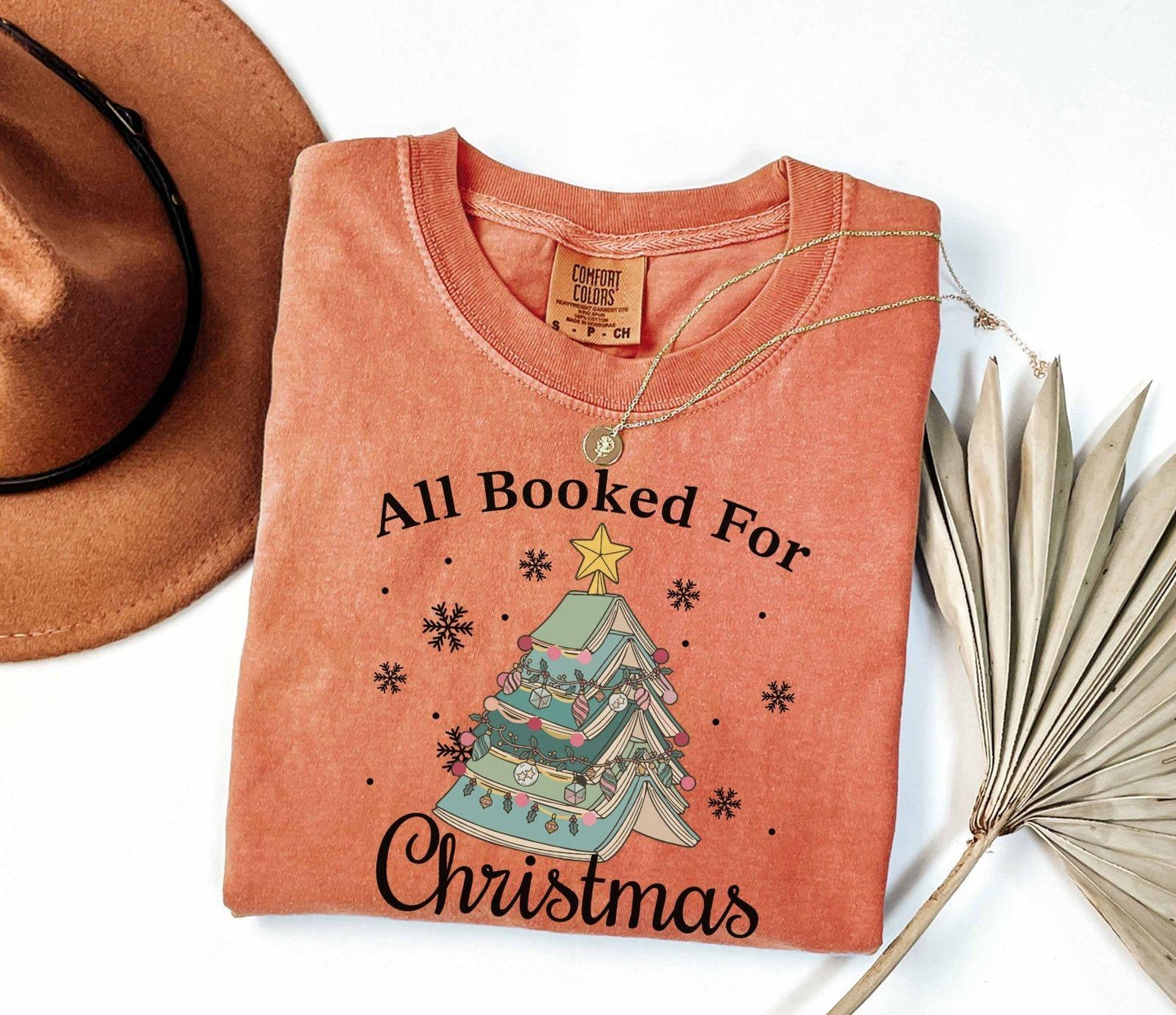 A comfort colors® shirt with the saying "All booked for Christmas"