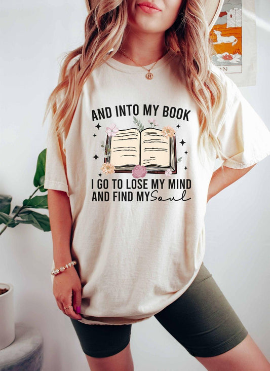 A comfort colors shirt with the saying "And into my book I go to lose my mind and find my soul"