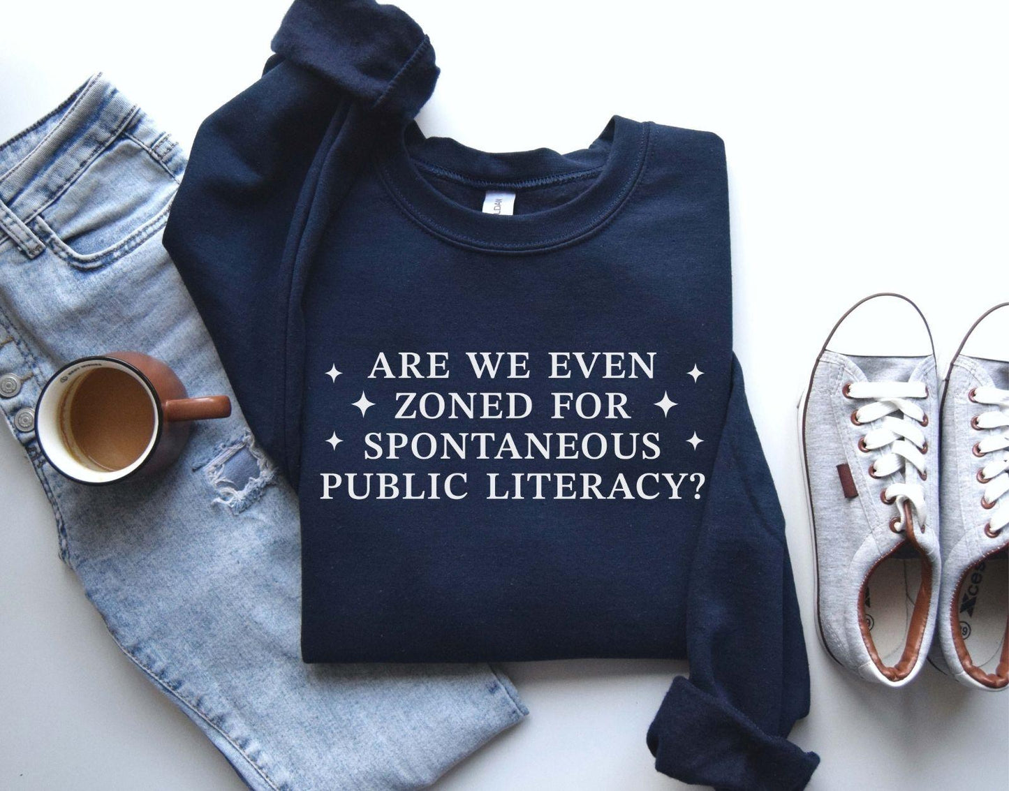 A Gildan 18000 sweatshirt with the saying "Are We Even Zoned For Spontaneous Public Literacy"