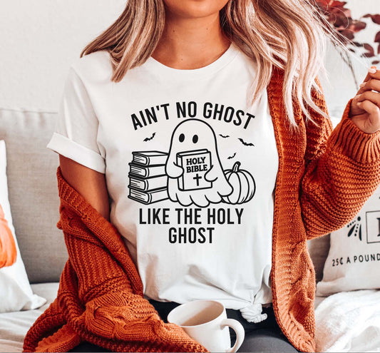 Person wearing a white t-shirt with a ghost graphic and text, sitting on a couch.