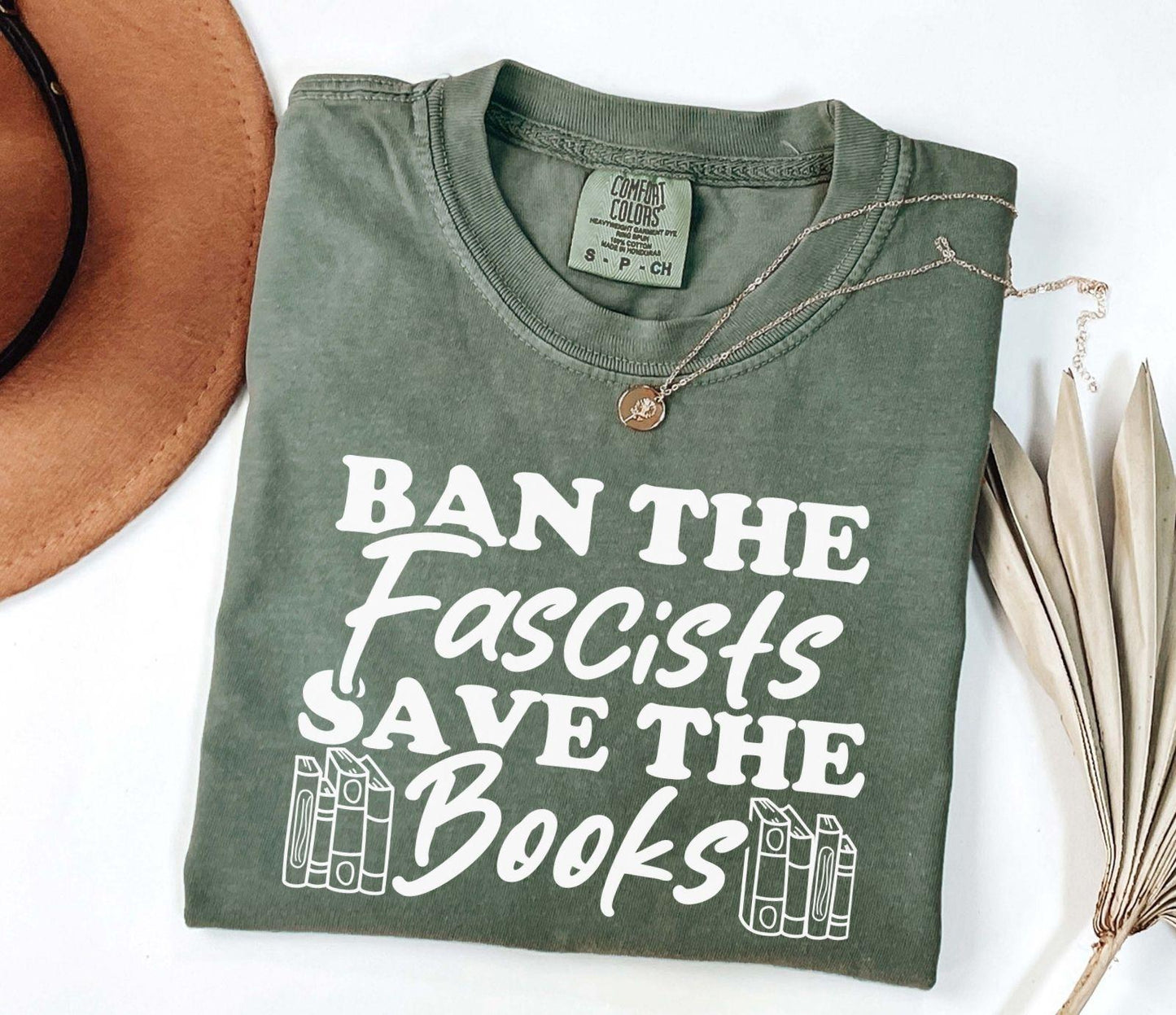 A comfort colors shirt with the saying "Ban the fascists save the books"