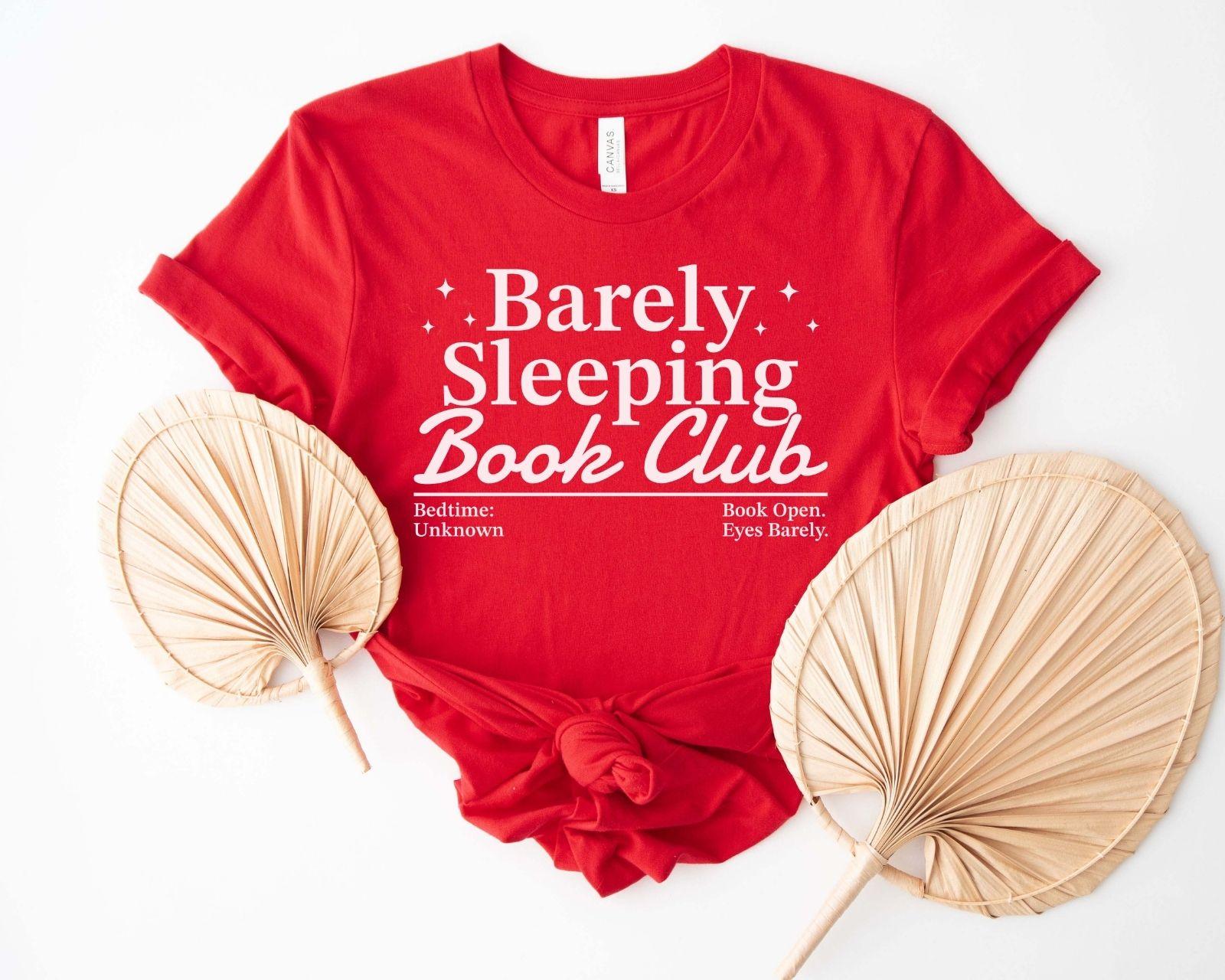 A bella canvas 3001 shirt with the saying "Barely sleeping book club"