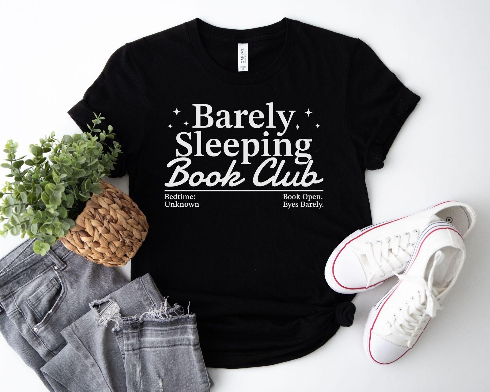 A bella canvas 3001 shirt with the saying "Barely sleeping book club"