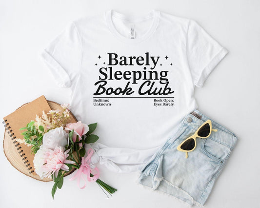 A bella canvas 3001 shirt with the saying "Barely sleeping book club"