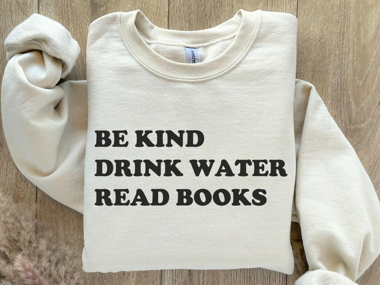 A Gildan 18000 sweatshirt with the saying "be kind drink water read books"