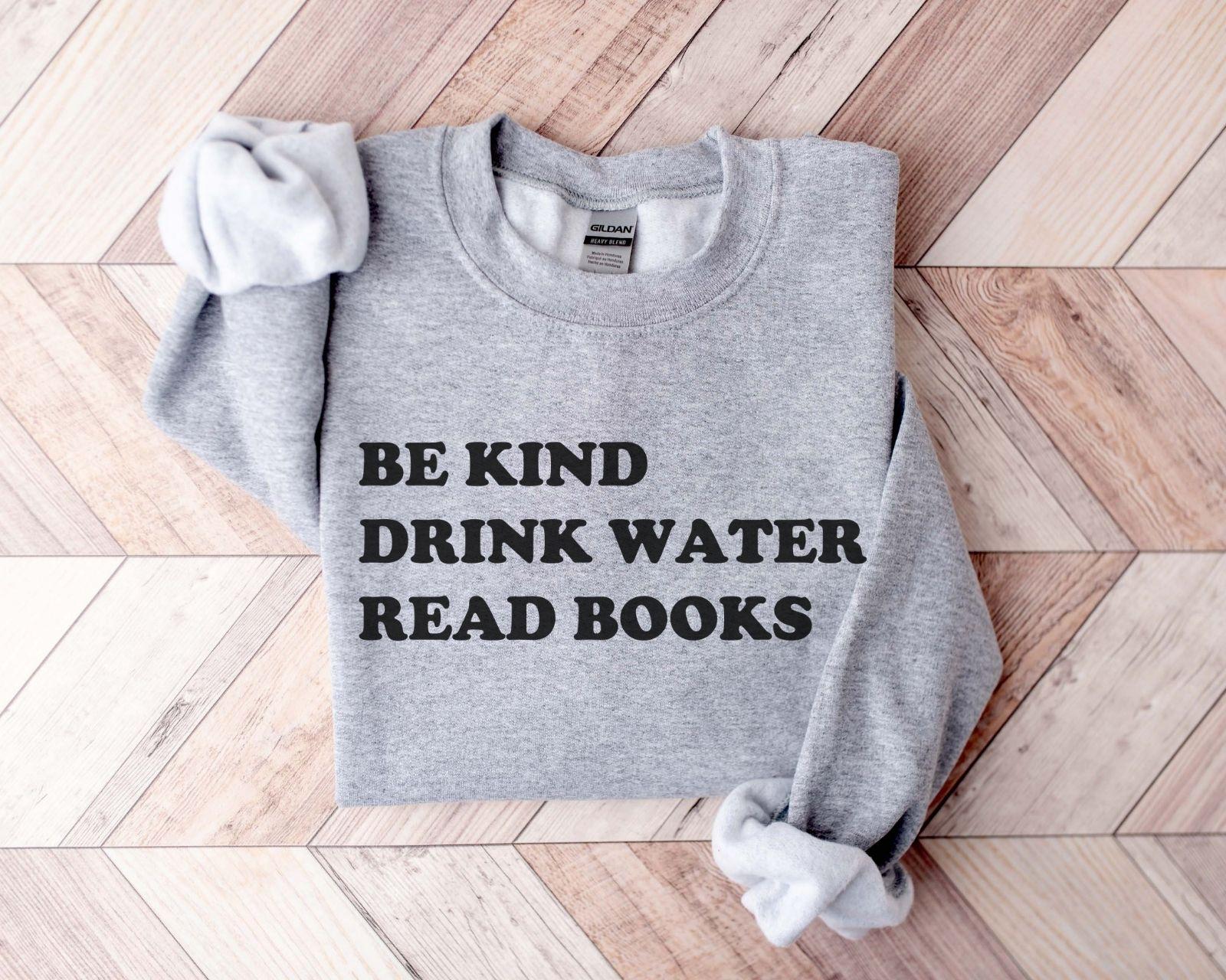A Gildan 18000 sweatshirt with the saying "be kind drink water read books"