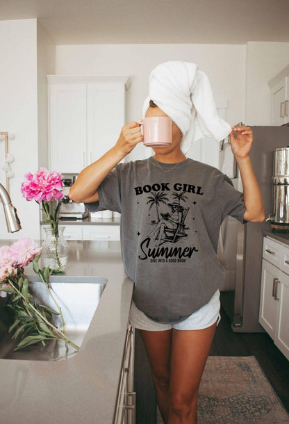 A comfort colors shirt with the saying "book girl summer dive into a good book"