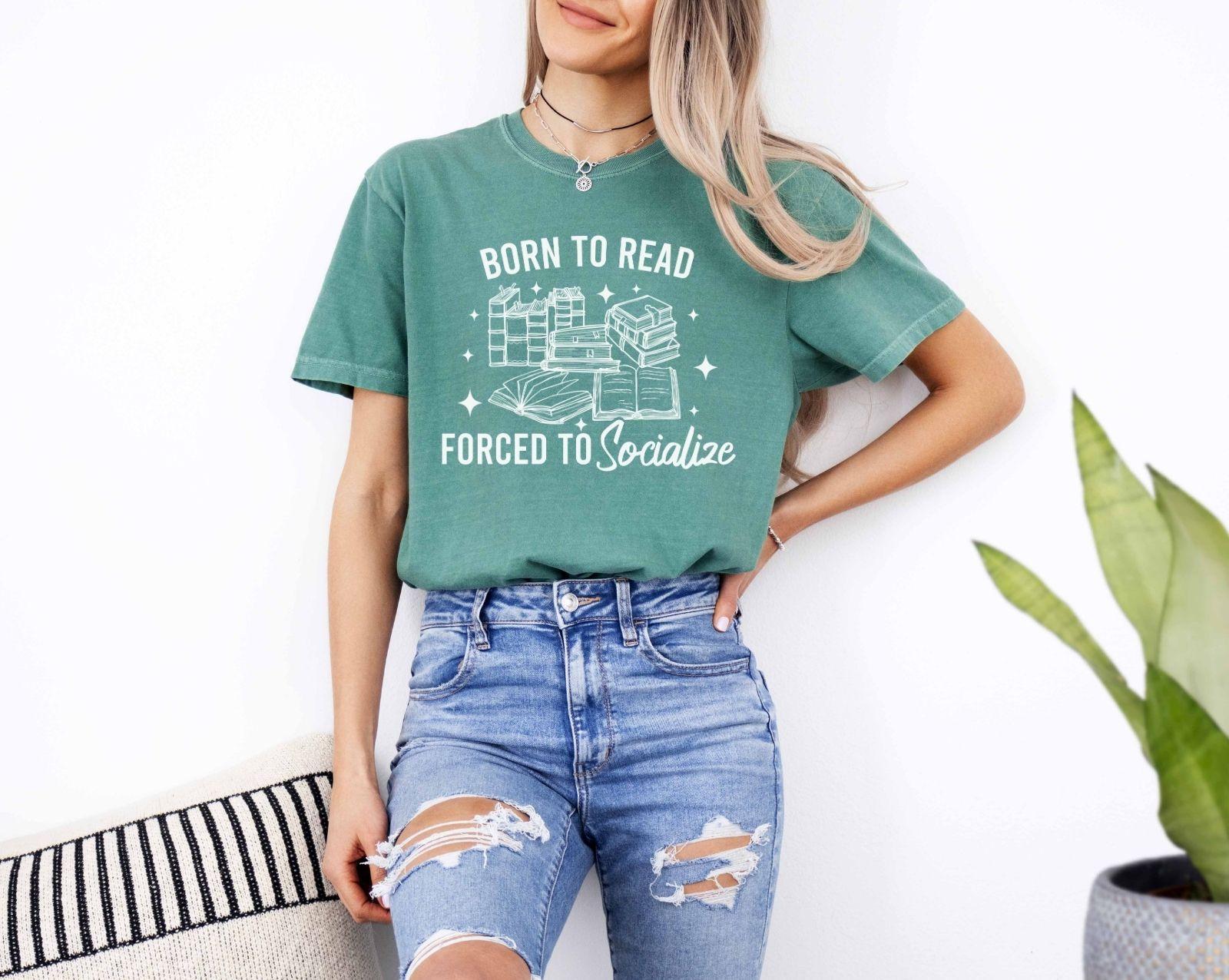 A comfort colors shirt with the saying "Born To Read Forced To socialize"