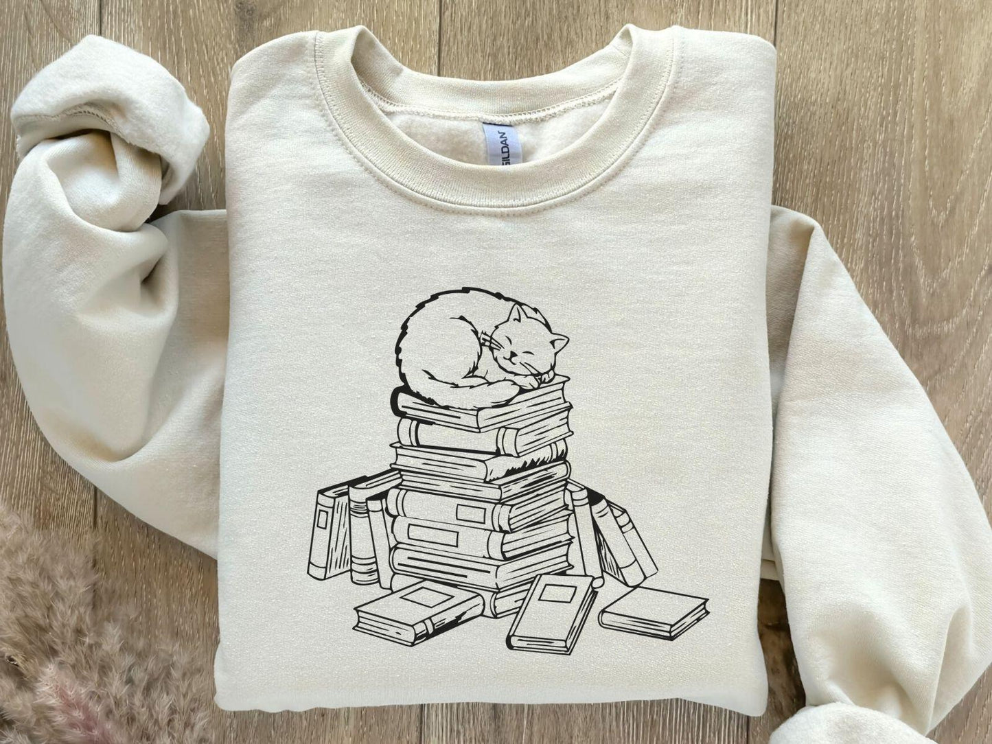 A Gildan 18000 sweatshirt with the saying "a cat with books"