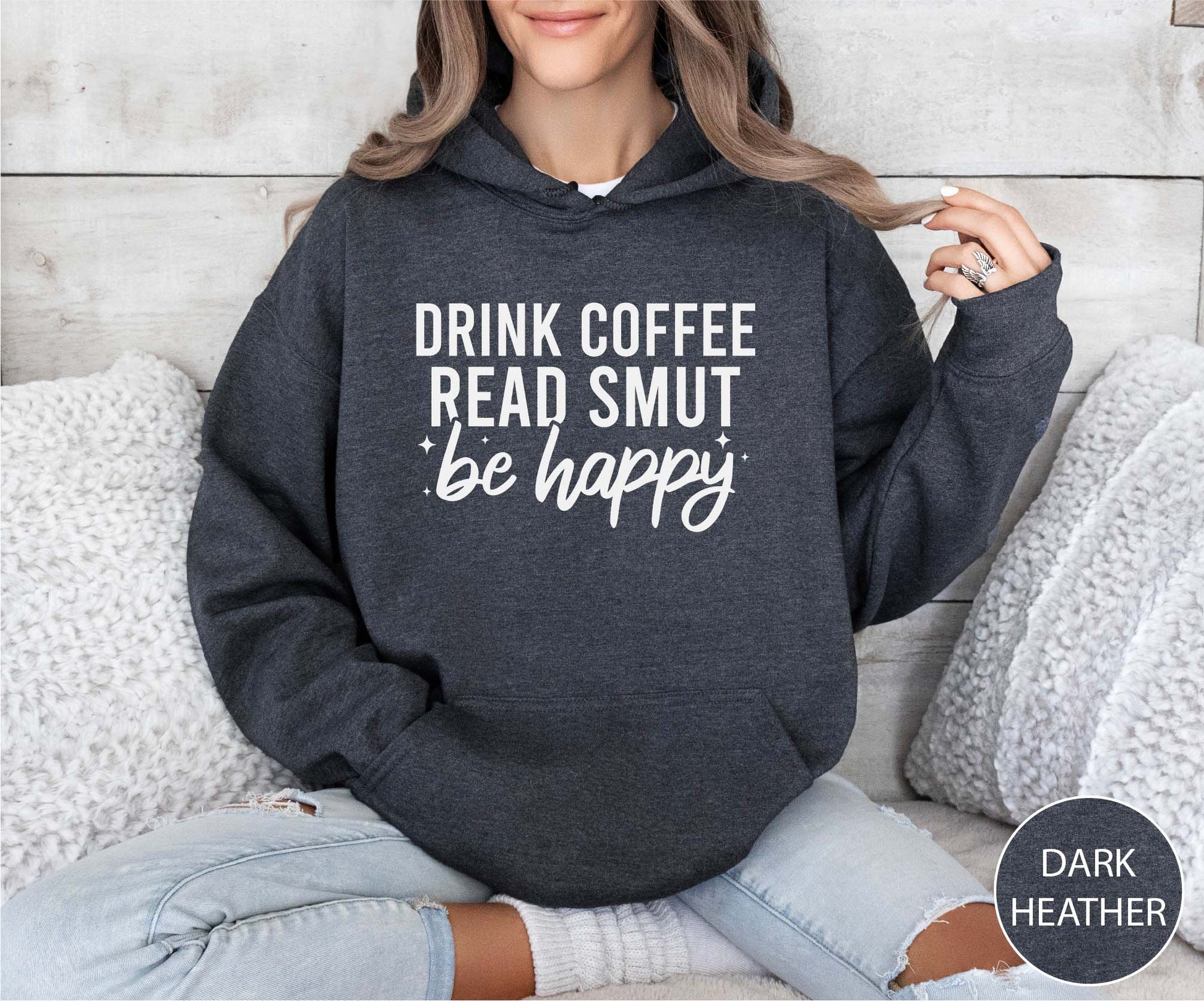 Person wearing a dark Heather hoodie with text, sitting on a couch.