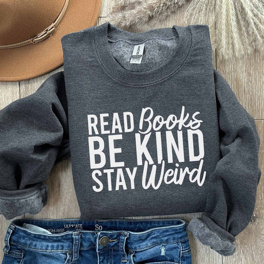 A dark heather color sweatshirt with the saying "Read books be kind stay weird"