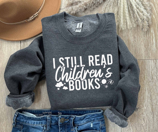 A dark heather color sweatshirt with the saying "I still read children's books"