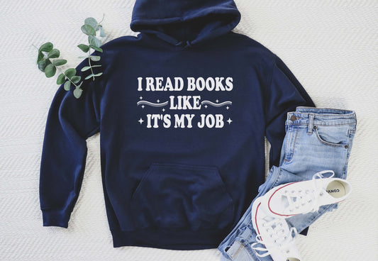 Navy blue hoodie with 'I Read Books Like It's My Job' text, paired with jeans and sneakers on a light background