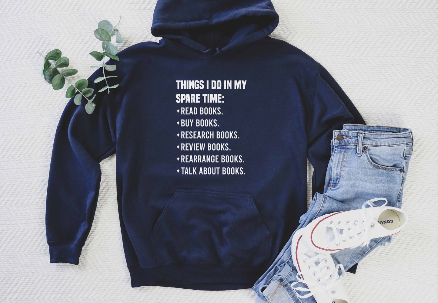 Navy blue hoodie with text on a white background, paired with jeans and sneakers.