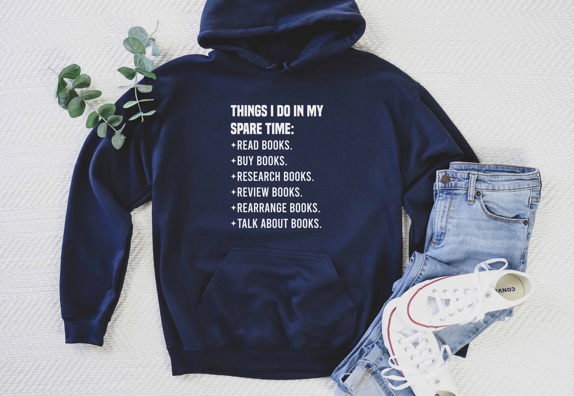 Navy blue hoodie with text on a white background, paired with jeans and sneakers.