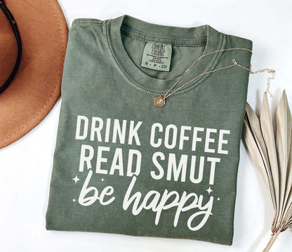 A comfort colors shirt with the saying "Drink coffee read books be happy"