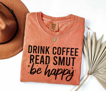 A comfort colors shirt with the saying "Drink coffee read books be happy"