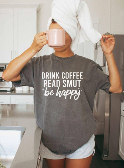 A comfort colors shirt with the saying "Drink coffee read books be happy"