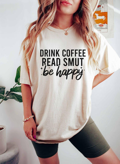 A comfort colors shirt with the saying "Drink coffee read books be happy"