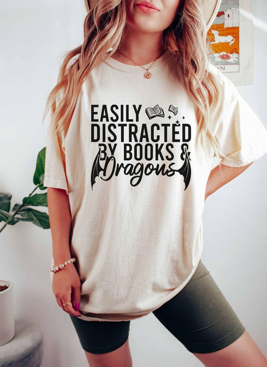 A comfort colors® shirt with the saying "Easily distracted by books and dragons"