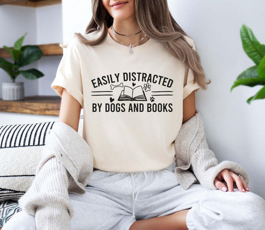 A bella canvas 3001 shirt with the saying "Easily distracted by dogs and books"