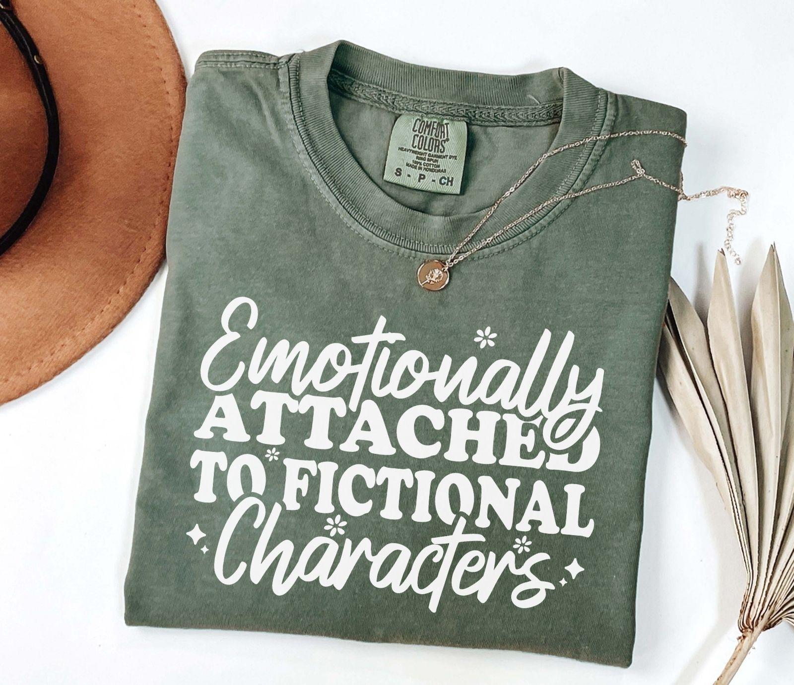 A comfort colors® shirt with the saying "Emotionally attached to fictional characters"
