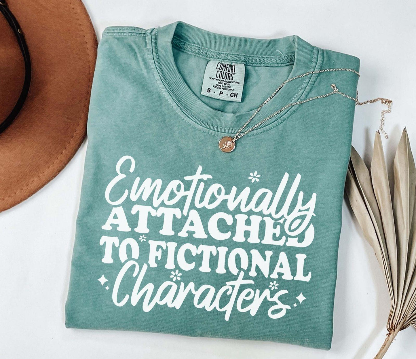 A comfort colors® shirt with the saying "Emotionally attached to fictional characters"