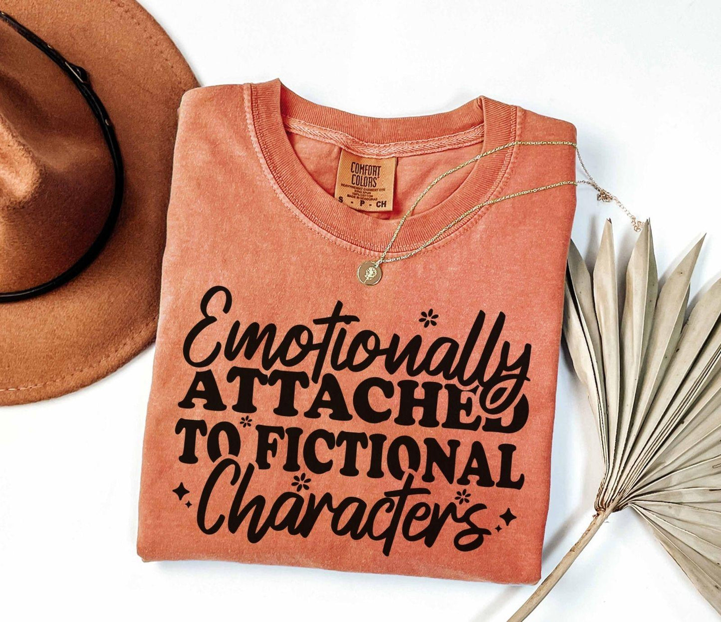 A comfort colors® shirt with the saying "Emotionally attached to fictional characters"