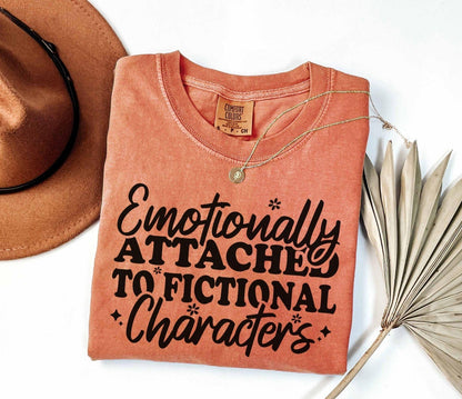A comfort colors® shirt with the saying "Emotionally attached to fictional characters"