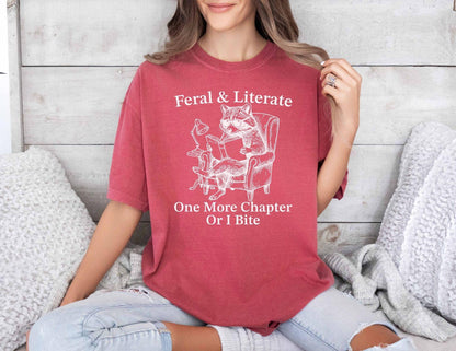 A comfort colors® shirt with the saying "Feral And Literate One More Chapter Or I Bite"