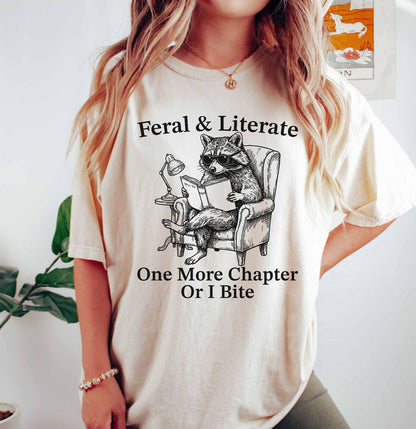 A comfort colors® shirt with the saying "Feral And Literate One More Chapter Or I Bite"