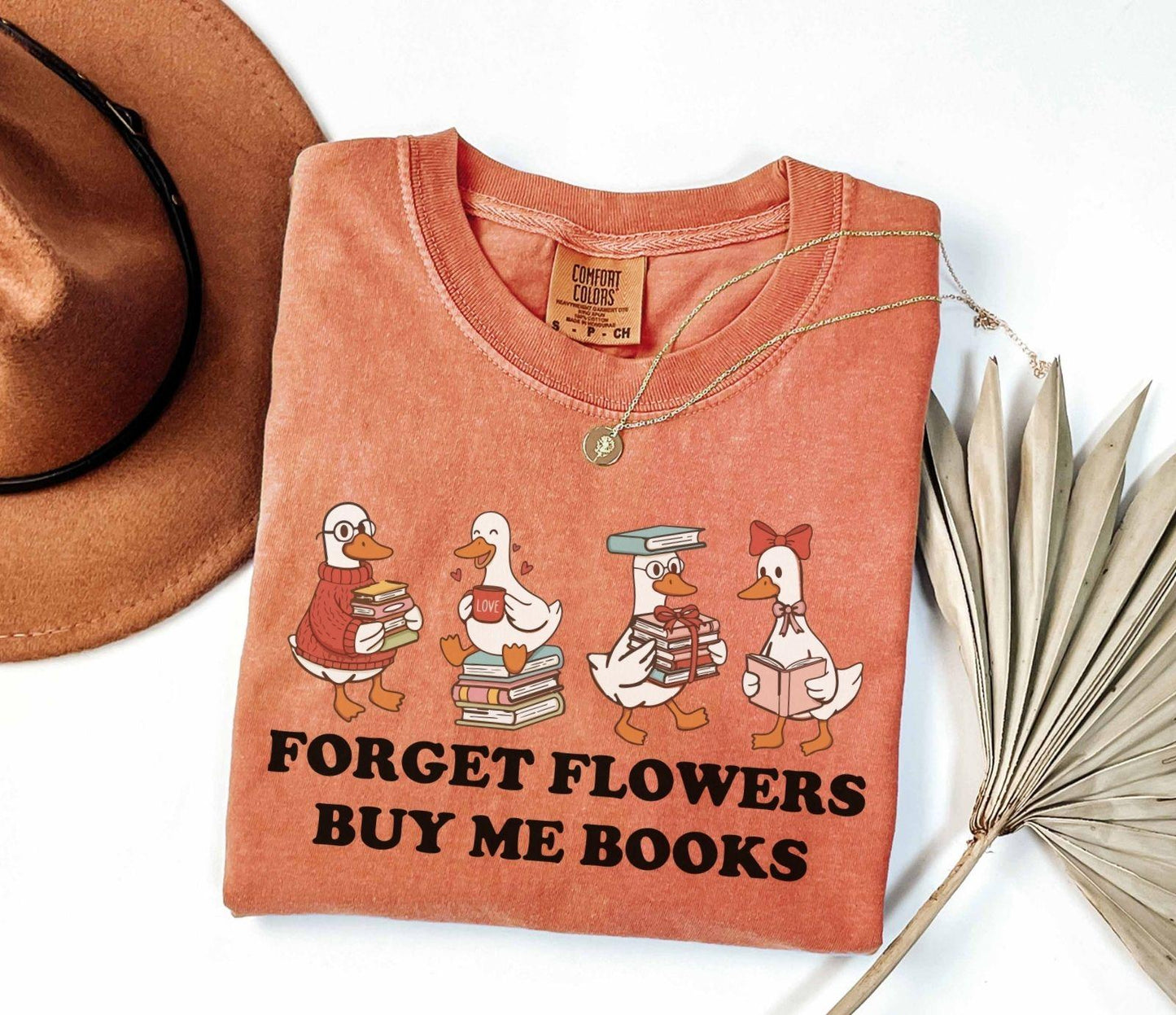 A comfort colors shirt with the saying "Forget flowers buy me books"