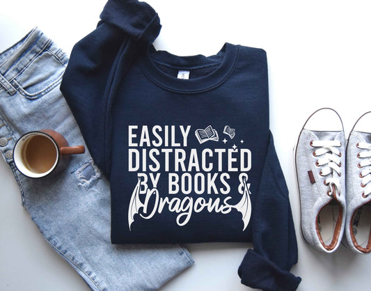 A navy color sweatshirt with the saying "Easily distracted by books and dragons"