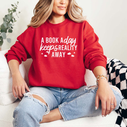 A red color sweatshirt with the saying "A book a day keeps reality away"