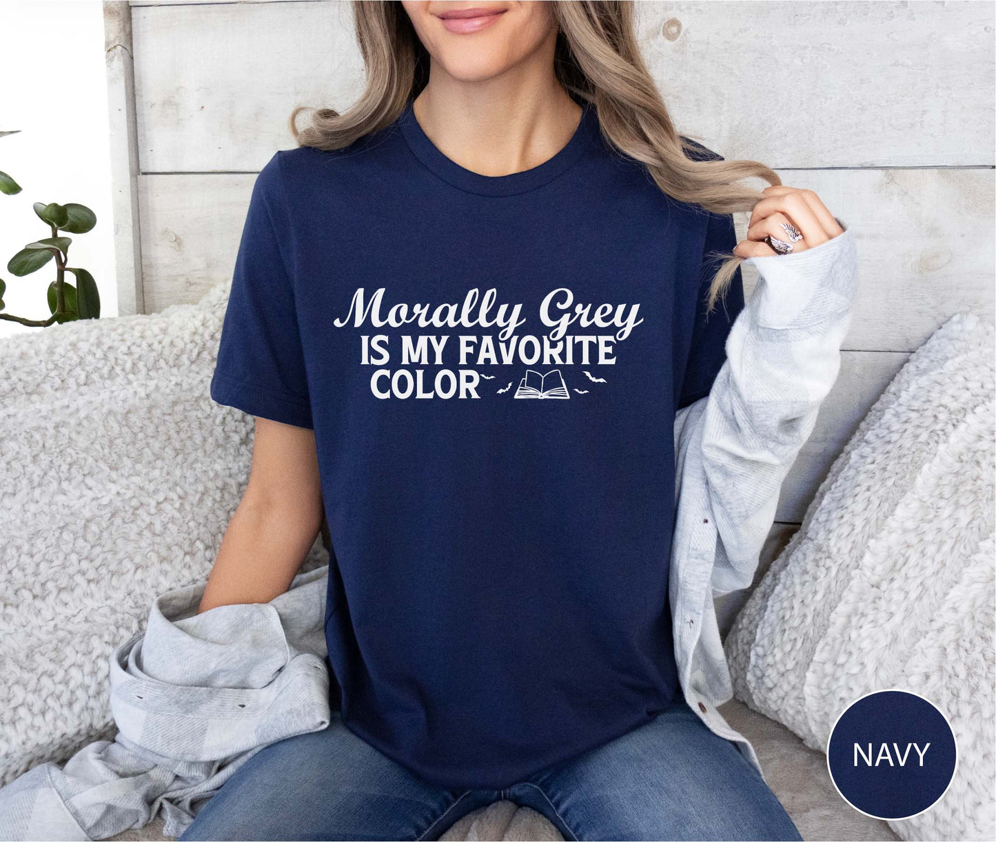 Person wearing a navy t-shirt with text, sitting on a couch.