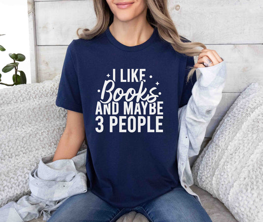 A navy color shirt with the saying "I like books and maybe 3 people"