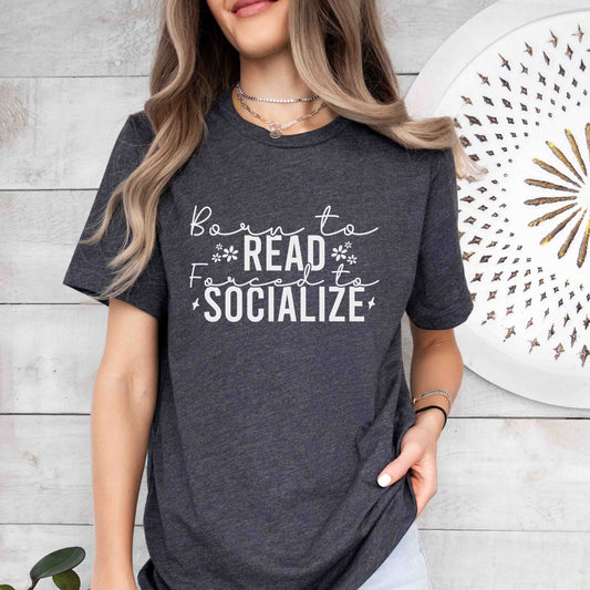A dark grey heather color with the saying "Born To Read Forced To Socialize"