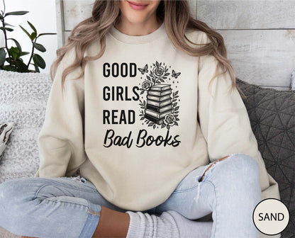 Person wearing a sand sweatshirt with 'Good girls read bad books' text and book graphic.
