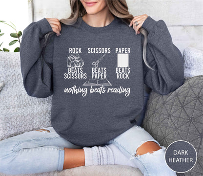 Person wearing a dark Heather sweatshirt with a graphic and text, sitting on a couch.