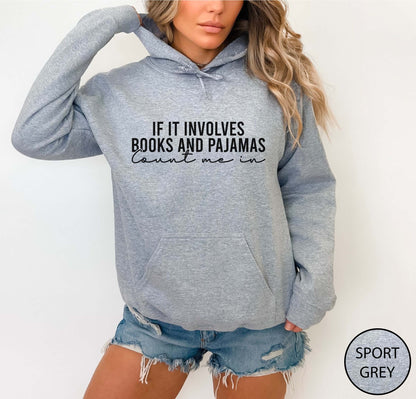 Person wearing a sport grey hoodie with text 'If it involves books and pajamas, count me in' on a white background.